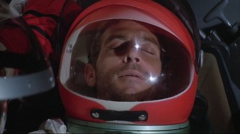 Movie still from “Marooned” (1969), directed by John Sturges – A man wearing a red and white space helmet; Close Up shot, Overhead angle