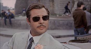 Movie still from “Marriage Italian Style” (1964), directed by Vittorio De Sica – A person wearing a suit and sunglasses; Close Up shot, Low angle