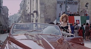 Movie still from “Marriage Italian Style” (1964), directed by Vittorio De Sica – A woman in a black and white dress driving a car; Wide shot, Low angle