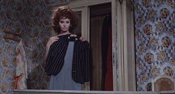 Movie still from “Marriage Italian Style” (1964), directed by Vittorio De Sica – A woman holding a suit jacket up to her face; Medium shot, Over the shoulder angle