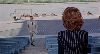 Movie still from “Marriage Italian Style” (1964), directed by Vittorio De Sica – A man in a suit and tie standing next to a woman in a suit; Wide shot, High angle