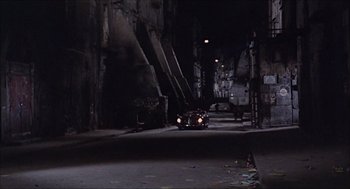 Movie still from “Marriage Italian Style” (1964), directed by Vittorio De Sica – A car driving down a dark street at night; Extreme Wide shot, High angle