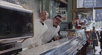 Movie still from “Marriage Italian Style” (1964), directed by Vittorio De Sica – A couple of men standing at a counter in front of a mirror; Medium shot, Low angle