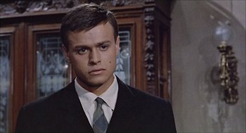 Movie still from “Marriage Italian Style” (1964), directed by Vittorio De Sica – A man wearing a suit and tie standing in front of a wall; Close Up shot, Low angle