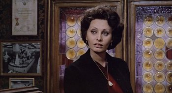 Movie still from “Marriage Italian Style” (1964), directed by Vittorio De Sica – A person wearing a suit and a necklace; Close Up shot, Over the shoulder angle