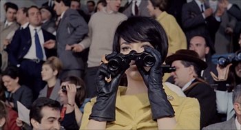 Movie still from “Marriage Italian Style” (1964), directed by Vittorio De Sica – A woman in a yellow dress holding a pair of binoculars; Medium shot, High angle