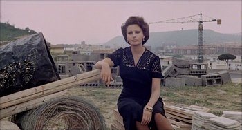 Movie still from “Marriage Italian Style” (1964), directed by Vittorio De Sica – A woman sitting on top of a pile of wood; Medium shot, Low angle
