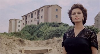 Movie still from “Marriage Italian Style” (1964), directed by Vittorio De Sica – A woman standing in front of an apartment building; Medium shot, Low angle