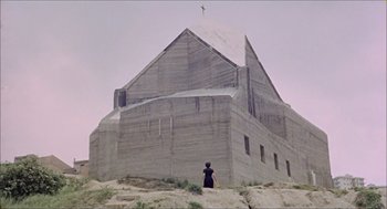 Movie still from “Marriage Italian Style” (1964), directed by Vittorio De Sica – A person standing in front of a large concrete building; Extreme Wide shot, Low angle