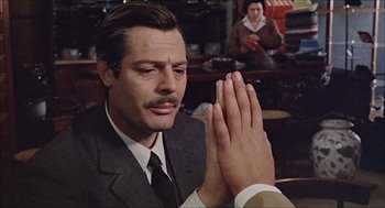 Movie still from “Marriage Italian Style” (1964), directed by Vittorio De Sica – A man in a suit and tie is praying; Close Up shot, Over the shoulder angle
