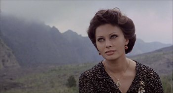 Movie still from “Marriage Italian Style” (1964), directed by Vittorio De Sica – A woman in a black dress is standing in front of a mountain range; Close Up shot, Over the shoulder angle