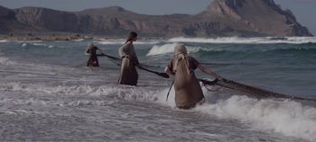 Movie still from “Mary Magdalene” (2018), directed by Garth Davis – A group of people in the water with nets in the ocean; Extreme Wide shot, High angle