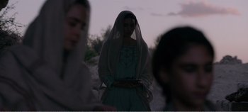 Movie still from “Mary Magdalene” (2018), directed by Garth Davis – A woman with a veil is standing in a field; Medium shot, Over the shoulder angle