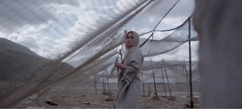 Movie still from “Mary Magdalene” (2018), directed by Garth Davis – A woman in a gray robe holding a stick; Medium shot, Low angle