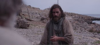 Movie still from “Mary Magdalene” (2018), directed by Garth Davis – A man with long hair and beard standing on top of a hill; Medium shot, Low angle
