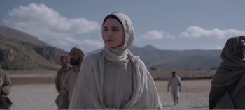 Movie still from “Mary Magdalene” (2018), directed by Garth Davis – A woman with a head covering is standing in the desert; Medium shot, Low angle
