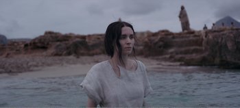 Movie still from “Mary Magdalene” (2018), directed by Garth Davis – A woman standing in front of a body of water; Medium shot, Over the shoulder angle