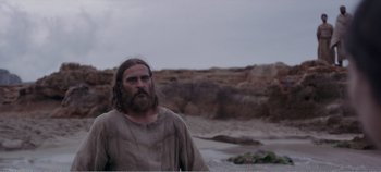 Movie still from “Mary Magdalene” (2018), directed by Garth Davis – A man with long hair and a beard standing in the water; Medium shot, Low angle