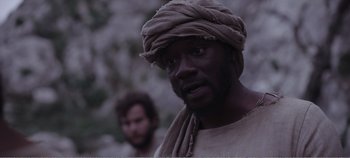 Movie still from “Mary Magdalene” (2018), directed by Garth Davis – A man with a beard and a turban is looking at the camera; Close Up shot, Over the shoulder angle