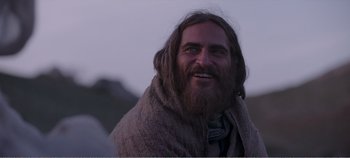 Movie still from “Mary Magdalene” (2018), directed by Garth Davis – A man with long hair and a beard smiling for the camera; Close Up shot, Over the shoulder angle