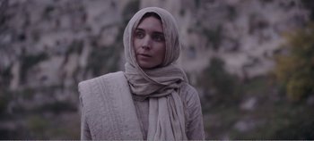 Movie still from “Mary Magdalene” (2018), directed by Garth Davis – A woman wearing a head covering and a scarf; Close Up shot, Over the shoulder angle