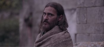 Movie still from “Mary Magdalene” (2018), directed by Garth Davis – A man with long hair and a beard wearing a blanket; Close Up shot, Over the shoulder angle