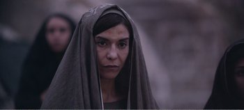 Movie still from “Mary Magdalene” (2018), directed by Garth Davis – A woman wearing a head covering and looking into the camera; Close Up shot, Over the shoulder angle