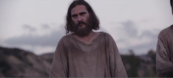 Movie still from “Mary Magdalene” (2018), directed by Garth Davis – A man with long hair and a beard is standing outside; Medium shot, Low angle
