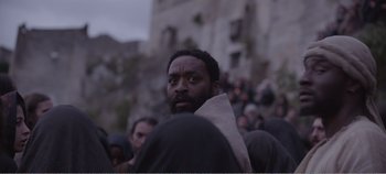 Movie still from “Mary Magdalene” (2018), directed by Garth Davis – A man with a beard is standing in a crowd of people; Medium shot, Low angle