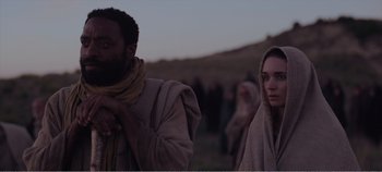 Movie still from “Mary Magdalene” (2018), directed by Garth Davis – A man and a woman standing next to each other in a field; Medium shot, Over the shoulder angle