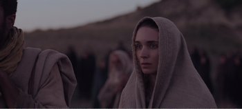Movie still from “Mary Magdalene” (2018), directed by Garth Davis – A woman with a towel around her neck and a blanket over her head; Close Up shot, Over the shoulder angle