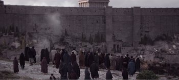 Movie still from “Mary Magdalene” (2018), directed by Garth Davis – A group of people standing around a wall; Extreme Wide shot, High angle