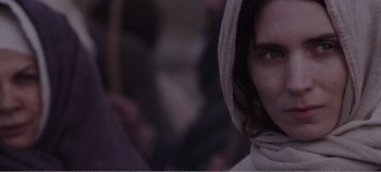 Movie still from “Mary Magdalene” (2018), directed by Garth Davis – A person wearing a hooded sweatshirt; Close Up shot, Over the shoulder angle