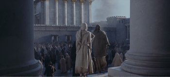Movie still from “Mary Magdalene” (2018), directed by Garth Davis – A group of people walking around a building; Extreme Wide shot, High angle