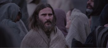 Movie still from “Mary Magdalene” (2018), directed by Garth Davis – A man with long hair and a beard is wearing a blanket; Close Up shot, Over the shoulder angle