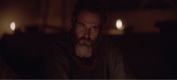 Movie still from “Mary Magdalene” (2018), directed by Garth Davis – A man with a long beard is sitting in a dark room; Close Up shot, Low angle