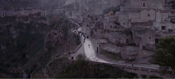 Movie still from “Mary Magdalene” (2018), directed by Garth Davis – People are walking down a road on a cloudy day; Extreme Wide shot, High angle