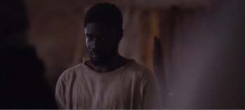 Movie still from “Mary Magdalene” (2018), directed by Garth Davis – A man in a white shirt is looking at the camera; Close Up shot, High angle