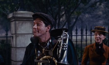 Movie still from “Mary Poppins” (1964), directed by Robert Stevenson – A man in a hat and a jacket is holding a trombone; Medium shot, Low angle