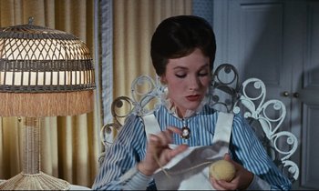 Movie still from “Mary Poppins” (1964), directed by Robert Stevenson – A woman in a striped shirt is sewing a ball of yarn; Medium shot, Low angle