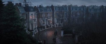 Movie still from “Mary Poppins Returns” (2018), directed by Rob Marshall – A horse drawn carriage rides down the street in the dark; Extreme Wide shot, High angle