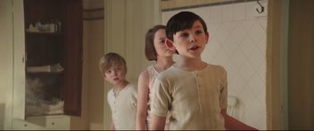 Movie still from “Mary Poppins Returns” (2018), directed by Rob Marshall – Three young children standing in a line in front of a mirror; Medium shot, Low angle