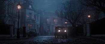 Movie still from “Mary Poppins Returns” (2018), directed by Rob Marshall – An old car parked in front of a house at night; Extreme Wide shot, Low angle