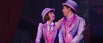 Movie still from “Mary Poppins Returns” (2018), directed by Rob Marshall – A man and a woman dressed in purple and pink; Medium shot, Over the shoulder angle