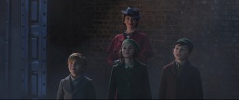 Movie still from “Mary Poppins Returns” (2018), directed by Rob Marshall – A group of people standing next to each other in front of a brick wall; Medium shot, Low angle