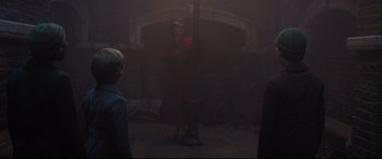 Movie still from “Mary Poppins Returns” (2018), directed by Rob Marshall – A man in a red coat and a red hat; Wide shot, Over the shoulder angle