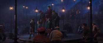 Movie still from “Mary Poppins Returns” (2018), directed by Rob Marshall – A group of people standing on top of a stage; Wide shot, Low angle