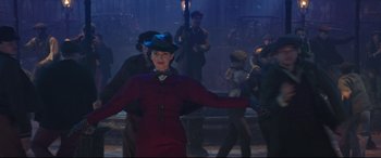 Movie still from “Mary Poppins Returns” (2018), directed by Rob Marshall – A woman in a red dress and blue hat is dancing; Medium shot, Low angle