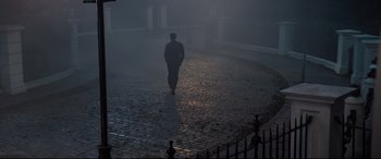 Movie still from “Mary Poppins Returns” (2018), directed by Rob Marshall – A man is walking in the dark on a foggy day; Extreme Wide shot, High angle