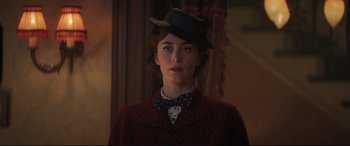 Movie still from “Mary Poppins Returns” (2018), directed by Rob Marshall – A woman in a hat and bow tie standing in front of a mirror; Close Up shot, Low angle